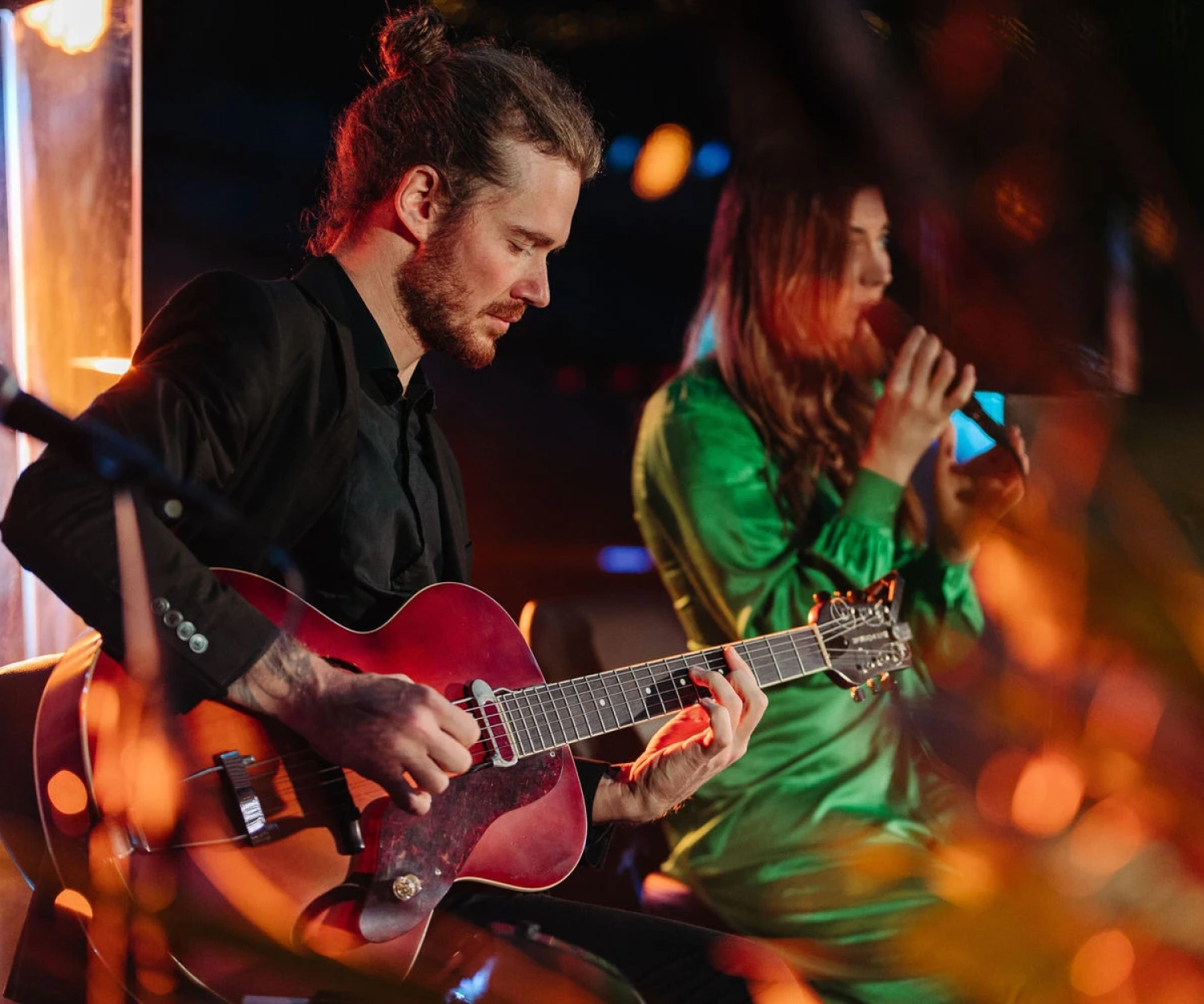 Duo with guitar and singer in a green dress performing at a corporate event